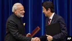  India's Prime Minister Narendra Modi, left, and Japan's Prime Minister Shinzo Abe shake hands after signing a joint statement at Abe's official residence in Tokyo, Japan.