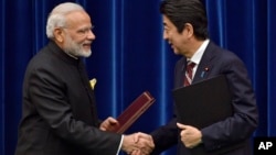 일본을 방문한 나렌드라 모디 인도 총리(왼쪽)가 11일 도쿄에서 아베 신조 일본 총리와 협정 서명식에 이어 악수하고 있다.