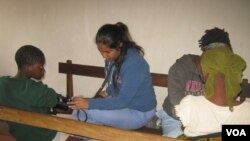 Mercer students Kamjeet Kaur (left) and Nancy Price check patients' vital signs at Chuluchosema clinic. (VOA/L.Masina) 