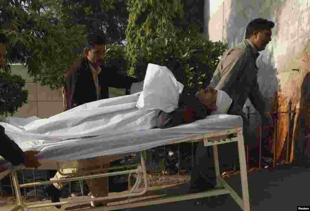 Men move a policeman by stretcher who was wounded after being hit by stones during a protest organized by Islami Jamiat-e-Talaba (JTI), the student wing of religious political party Jamaat-e-Islami (JI), against the satirical French weekly newspaper Charlie Hebdo, Jan. 16, 2015.