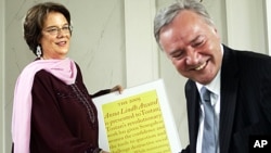 FILE - American Molly Melching, from the organization Tostan, receives the 2005 Anna Lindh Award, in Stockholm, June 16, 2005, from Bo Holmberg, widower of the late Swedish politician Anna Lindh who was murdered in 2003.