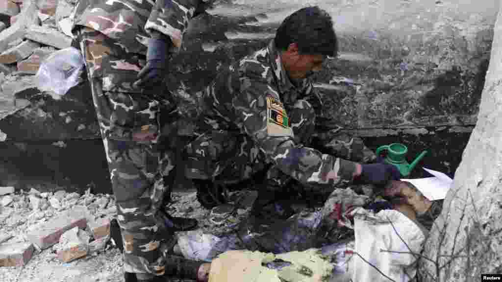 Afghan security personnel investigate at the site of a suicide attack in Kabul, November 21, 2012.