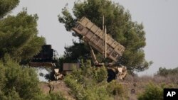 FILE - An Israel soldier walks near a Patriot missile defense battery positioned on the Carmel Mount, Israel, Oct. 9, 2012.