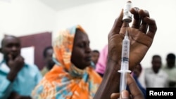 FILE - Staff members of the Teaching Hospital receive a vaccination for yellow fever in El Geneina, West Darfur, Nov. 14, 2012.