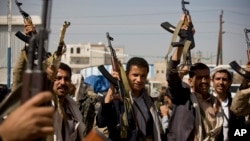 Houthi Shi'ite Yemeni show their weapons during clashes near the presidential palace in Sana'a, Yemen, Jan. 19, 2015.