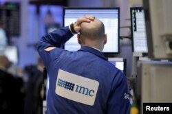 A trader works on the main trading floor of the New York Stock Exchange shortly after the opening bell of the trading session in the Manhattan borough of New York City, Jan. 7, 2016.