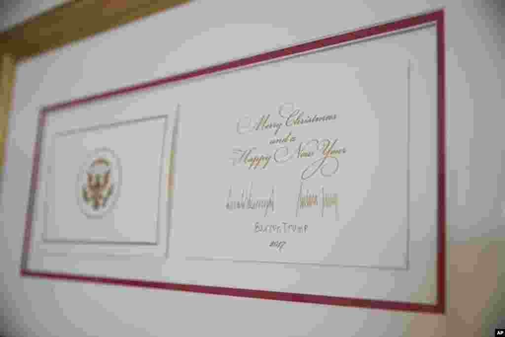 La tarjeta festiva oficial de Navidad de la Casa Blanca firmada por el presidente Donald Trump, la primera dama Melania Trump y su hijo Barron Trump, se ve como parte de la decoración festiva en la Casa Blanca en Washington, el lunes 27 de noviembre de 2017.