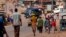 FILE - People walk as security forces traveling in a truck patrol a street in the Ivory Coast in Dec. 2010.