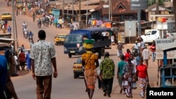 FILE - People walk as security forces travelling in a truck patrol a street in Gagnoa in western Ivory Coast, Dec. 2, 2010.