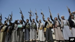 FILE - Shi'ite Houthi tribesmen hold their weapons as they chant slogans during a tribal gathering showing support for the Houthi movement, in Sana'a, Yemen.