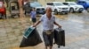 A local resident carries food and his luggage to a temporary shelter in a primary school ahead of the expected landfall of Super Typhoon Yagi in Wenchang, in southern China's Hainan province on Sept. 6, 2024. 