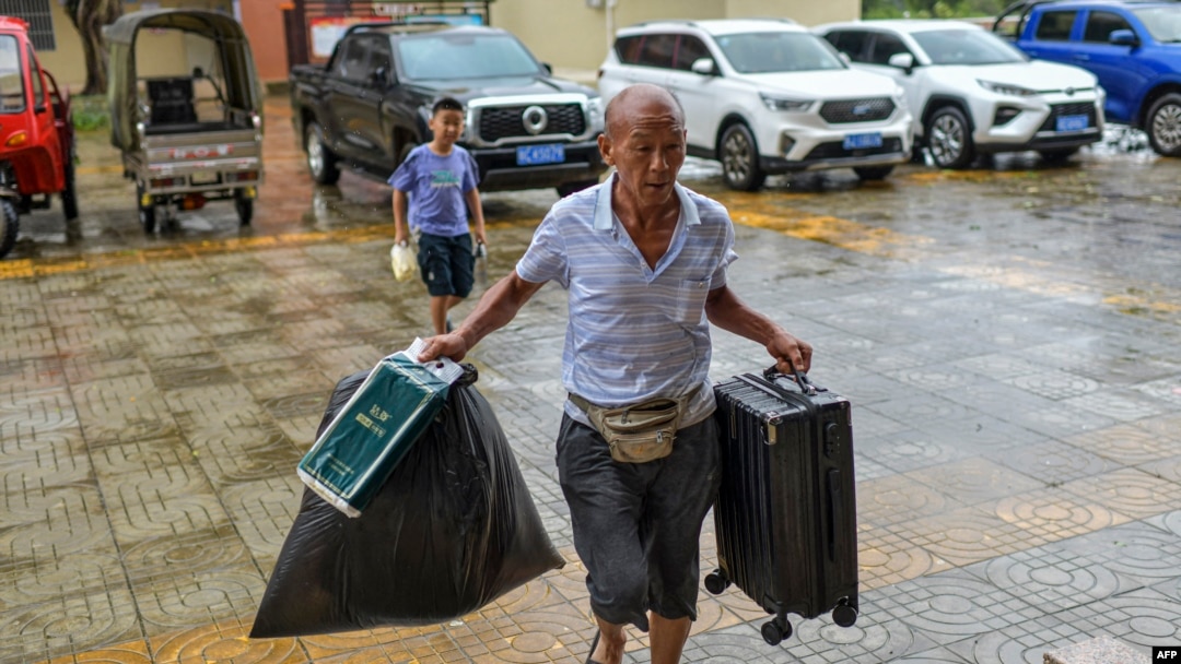 Seorang warga membawa makanan dan koper ke tempat penampungan sementara menjelang Topan Super Yagi di Wenchang, Provinsi Hainan, China, Jumat, 6 September 2024. (Foto: CNS/AFP)