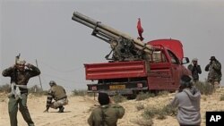 Libyan rebels prepare to fire a rocket launcher at the front line outside Brega, April 2, 2011