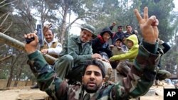 Lîbyayî li ser wesayîteke zirxîn pîrozbahî dikin û teqe li banî dikin. Şahat, Lîbya, 24, 02,2011