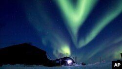 FILE - In this March 9, 2018, photo provided by the U.S. Navy, the aurora borealis displays above Ice Camp Skate in the Beaufort Sea. Scientists are seeing melting in polar regions at times they don't expect, like winter, and in places they don't expect, like eastern Antarctica.