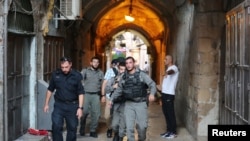 이스라엘 보안 병력이 15일 팔레스타인인들이 이스라엘 경찰에 의해 사살된 현장을 걸어가고 있다. 