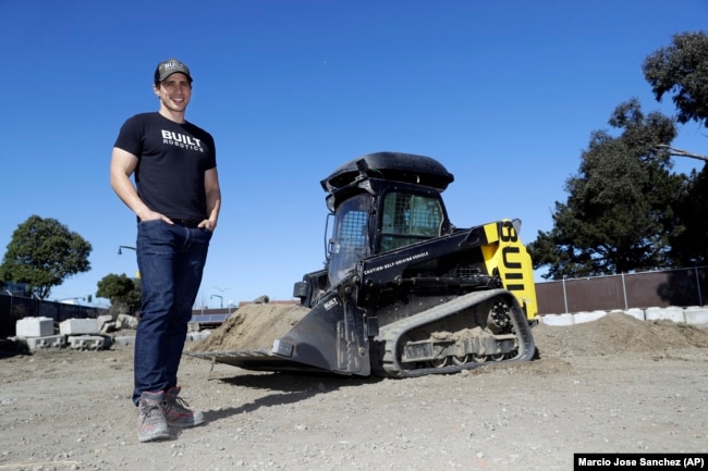 Built Robotics CEO Noah Ready-Campbell stands next to the company's self-driving track loader in San Francisco.