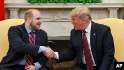 El presidente Donald Trump saluda a Joshua Holt, quien recientemente fue liberado de una prisión en Venezuela, en la Oficina Oval de la Casa Blanca, el 26 de mayo de 2018, en Washington.