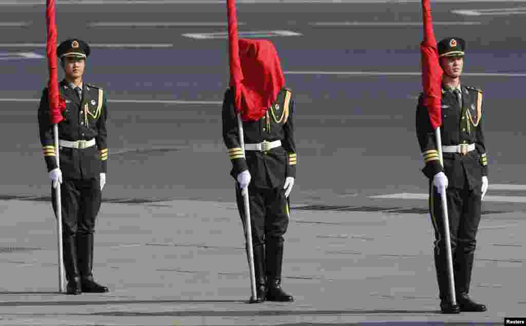 A flag covers the face of an honor guard during a welcoming ceremony for the visiting Mongolian Prime Minister Norovyn Altankhuyag outside the Great Hall of the People in Beijing, China. 