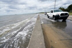Waters from the Gulf of Mexico poor onto a local road, in Waveland, Miss., Sept. 14, 2020.