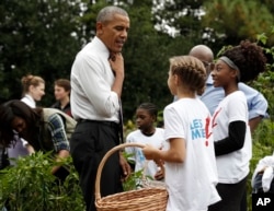 President Barack Obama loosens his tie as he visits the first lady Michelle Obama's White House Kitchen Garden harvest on the South Lawn White House in Washington, October 6, 2016.