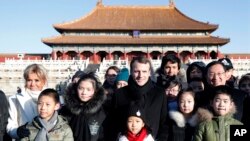 French President Emmanuel Macron, center, and his wife Brigitte Macron, left, pose for a photo with Chinese and French schoolchildren during a visit to the Forbidden City in Beijing Tuesday, Jan. 9, 2018. (Charles Platiau/Pool Photo via AP)