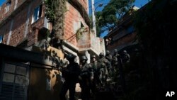 Soldados patrullan la barriada Chapeu Mangueira de Río de Janeiro, Brasil, el jueves 21 de junio de 2018. Casi 2.000 soldados participaron en una operación sorpresa como parte de acciones de seguridad lideradas por la intervención militar de Río de Janeiro. (AP Photo / Leo Correa)