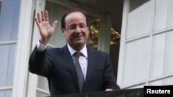 El presidente electo de Francia, Francois Hollande saluda desde el balcón de su cuartel de campaña, en Paris.