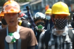 5일 미얀마 양곤에서 군부 쿠데타 반대 시위 참가자들이 헬멧과 마스크를 쓰고 있다. 미얀마에서는 최근 시위 진압 경찰의 발포로 시민 수십명이 숨진 것으로 알려졌다.