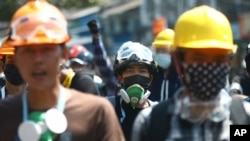 5일 미얀마 양곤에서 군부 쿠데타 반대 시위 참가자들이 헬멧과 마스크를 쓰고 있다. 미얀마에서는 최근 시위 진압 경찰의 발포로 시민 수십명이 숨진 것으로 알려졌다.