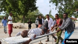 Residents transport a man wounded in crossfire during fighting between Somali government forces, backed by African Union troops, and Islamist militants in Madina District of Somalia's capital Mogadishu, Aug. 15, 2014. 