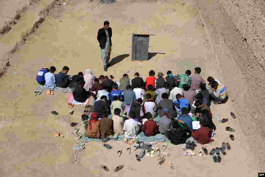 Afghan schoolchildren sit outdoors at an open classroom in Ghazni.