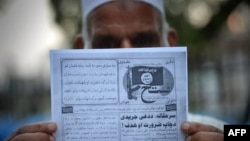 A Pakistani man holds a pamphlet, allegedly distributed by the Islamic State (IS), in the northwestern Pakistani city of Peshawar, Sept. 3, 2014 .