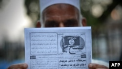 Seorang pria Pakistan memegang pamflet yang diduga disebarkan oleh militan Negara Islam (ISIS)di Peshawar, barat laut Pakistan. (AFP/A. Majeed)