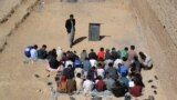 Afghan schoolchildren sit outdoors at an open classroom in Ghazni.
