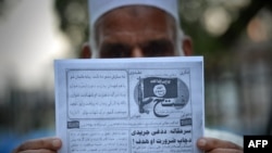 Seorang pria Pakistan memegang pamflet yang diduga disebarkan oleh militan Negara Islam (ISIS) di Peshawar, Pakistan, September 2014.