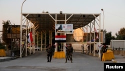 FILE - Iraqi security forces gather at a checkpoint into the Green Zone in Baghdad, Dec. 10, 2018.