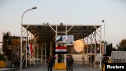 FILE - Iraqi security forces gather at a checkpoint into the Green Zone in Baghdad, Dec. 10, 2018.