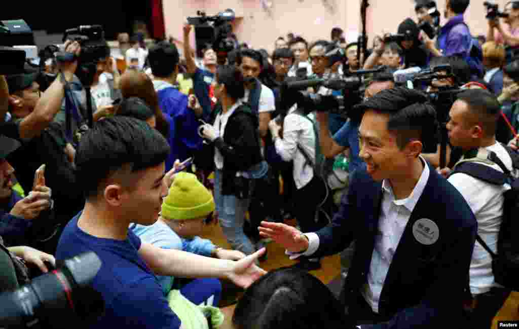 El candidato local Kelvin Lam celebra con sus seguidores después de que se anunció que ganó las elecciones del consejo local en su distrito, en una mesa electoral en el distrito South Horizons West en Hong Kong, China, el 25 de noviembre de 2019 (hora local).