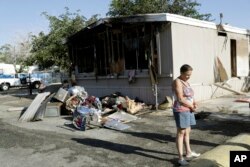 Katherine Johnson-Coates afuera de la casa móvil incendiada de un vecino después de un terremoto el sábado 6 de julio de 2019, en Ridgecrest, California.