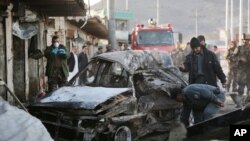 Afghan security personnel gather at the site of a suicide attack in Kabul, Afghanistan, April, 10, 2015. 