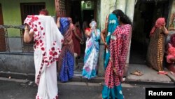 Indian sex workers cover their faces at the Sonagachi red-light area in Kolkata July 24, 2012.