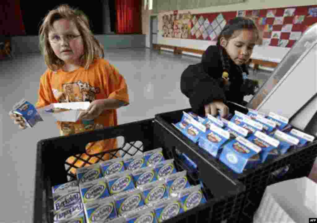 Fairmeadow Elementary School third grade students Ellery Carlson, left, and Tatiana Aboytes, right, pick chocolate milk during a school lunch program in Palo Alto, Calif., Thursday, Dec. 2, 2010. More children would eat lunches and dinners at school under