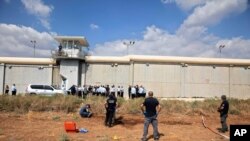 Police officers and prison guards inspect the scene of a prison escape outside the Gilboa prison in Northern Israel, Sept. 6, 2021. 