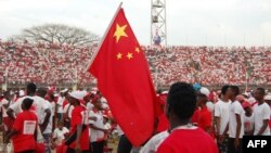 Les partisans du parti de l'APC (All People's Congress) en Sierra Leone brandissent un drapeau chinois lors d'un rassemblement au Stade national de Freetown le 28 février 2018