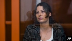 Ksenia Karelina, who is Russian American, sits in a glass cage in a court room in Yekaterinburg, Russia, on June 20, 2024. She is accused of treason.