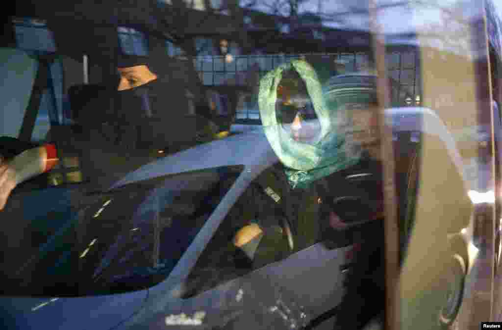 A German special police member sits beside a woman inside a police car after a raid of an apartment building in the Wedding district of Berlin, Germany, Jan. 16, 2015.
