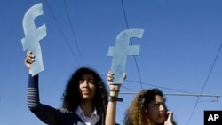 Protesters hold "f"s in recognition of social network site Facebook's role in the North African revolts, during a protest in Rabat, Morocco (Mar 2011 file photo)