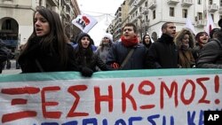 Protesters carry a banner which reads in Greek '' uprising '' during a protest in the northern port city of Thessaloniki, Greece, February 11, 2012.