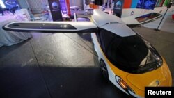 ລົດບິນໄດ້ຂອງບໍລິສັດ AeroMobil ທີ່ສາມາດບິນໄດ້ສູງເຖິງ 3,048 ແມັດ (10,000 ຟຸດ.) ໄກ 700 ກິໂລແມັດ ນໍາໄປວາງສະແດງທີ່ ງານວາງສະແດງ ດ້ານຜະລິດຕະພັນ ການບິນຄັ້ງທີ 52 ຢູ່ນະຄອນປາຣີ, ປະເທດຝຣັ່ງໃນວັນທີ 17 ມິຖຸນາ, 2017. REUTERS/Pascal Rossignol - RC12720A7D60
